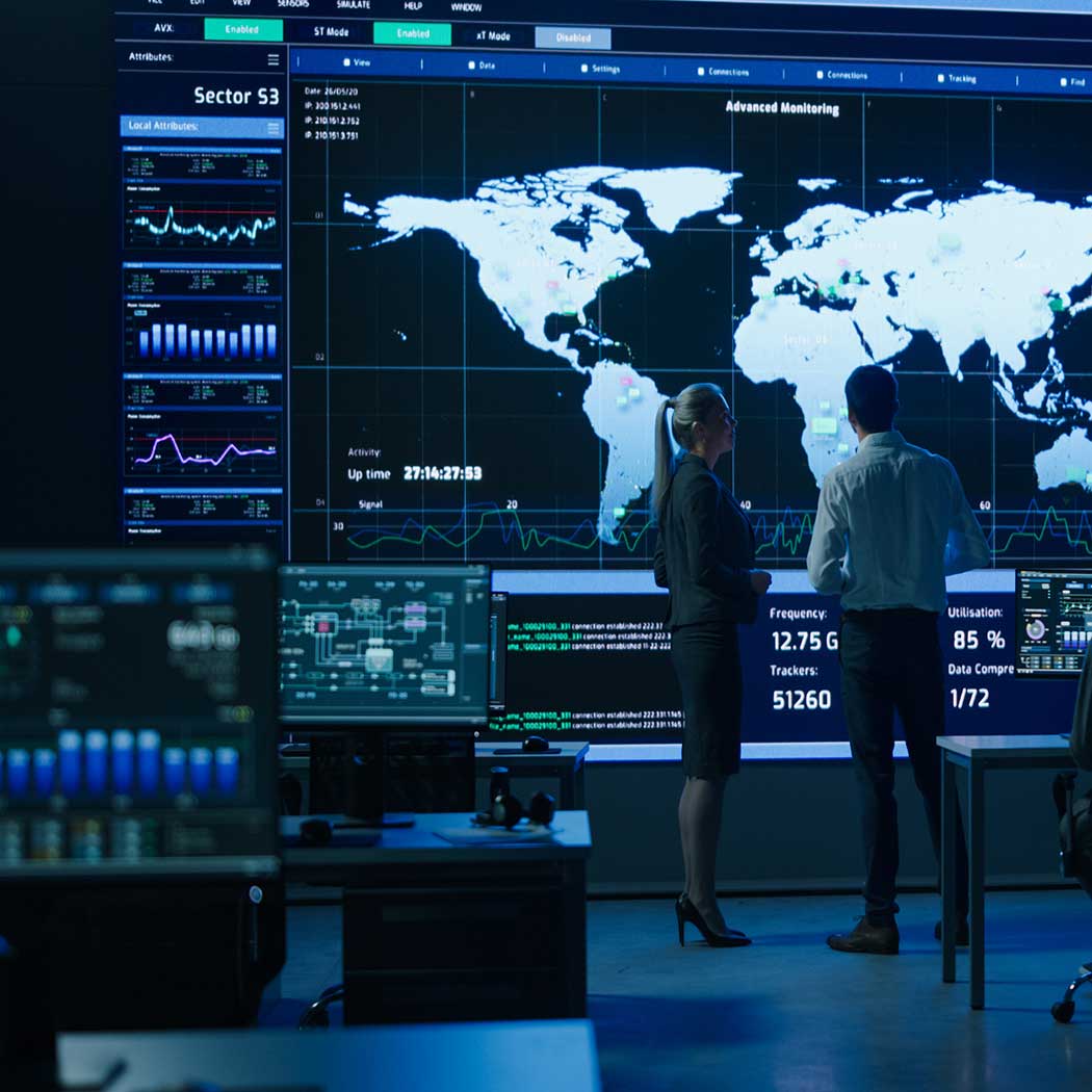 Two people analyzing a digital map, symbolizing the use of Cyber Transformation & Operations services to build resilient cyber defenses and manage security events, Cybersecurity | DXC Technology