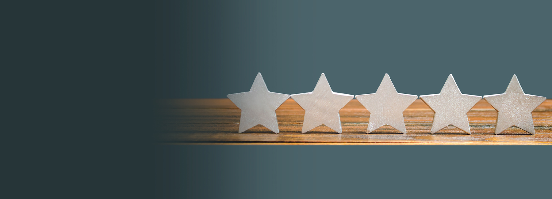 Five white stars aligned on wooden surface, Contact Center Experience | DXC Technology
