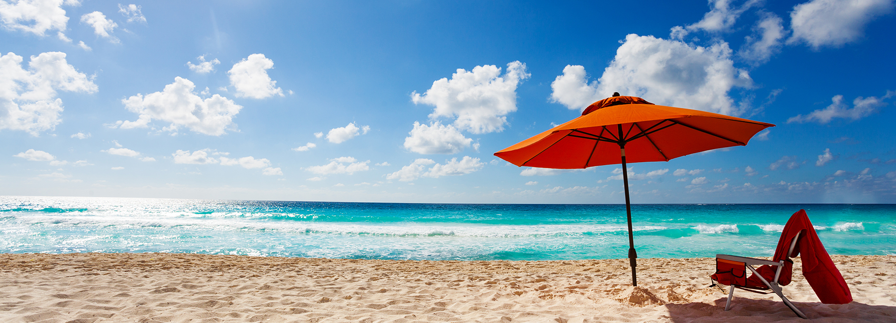 orange beach umbrella and chair at ocean edge, Insurance Software | DXC Technology