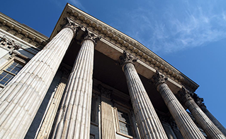 Outside view of the front of an imposing bank building, Support Services | DXC Technology Customer Story