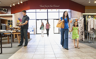 Young mother and daughter walking through bright retail space, in-store versus online shopping | DXC Technology Insights